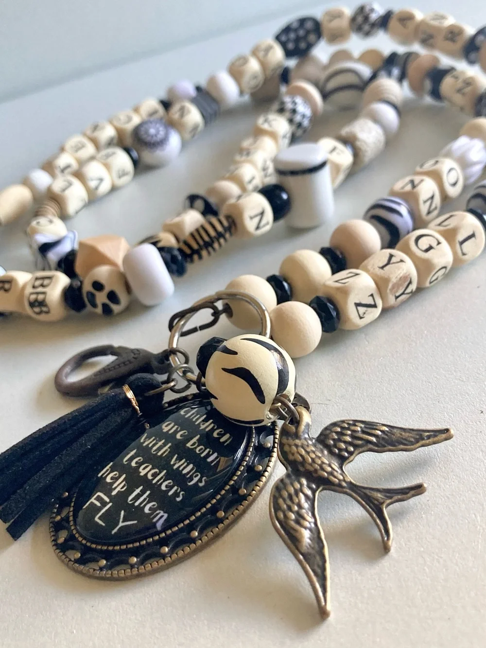 NWOT Plunder Black and Cream Beaded Pendant lanyard with Inspirational Charm